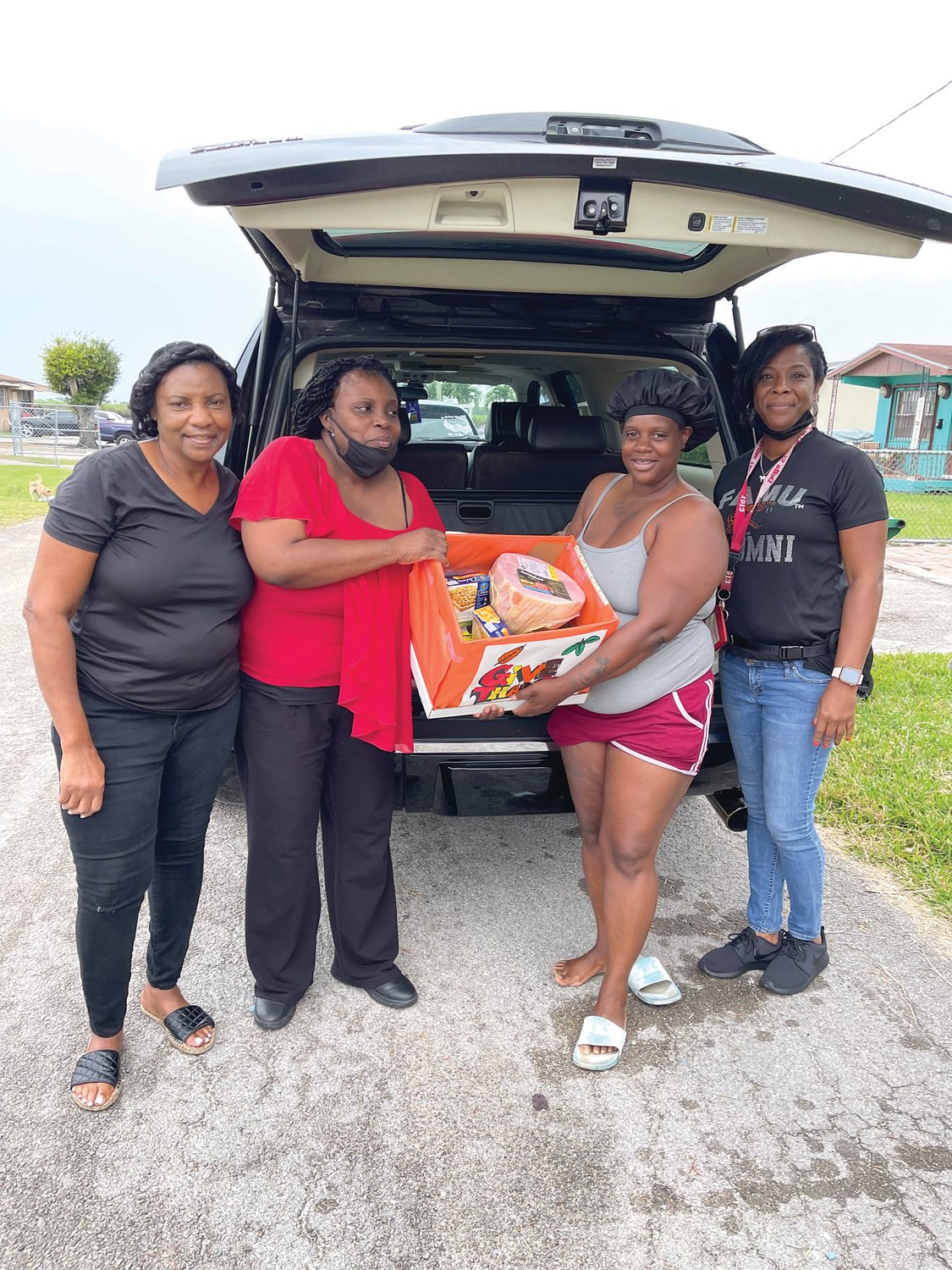 Gloria Robinson helps Barbara Johnson and Natasha Twiggs delivers a Thanksgiving Feast to the Williams Family.